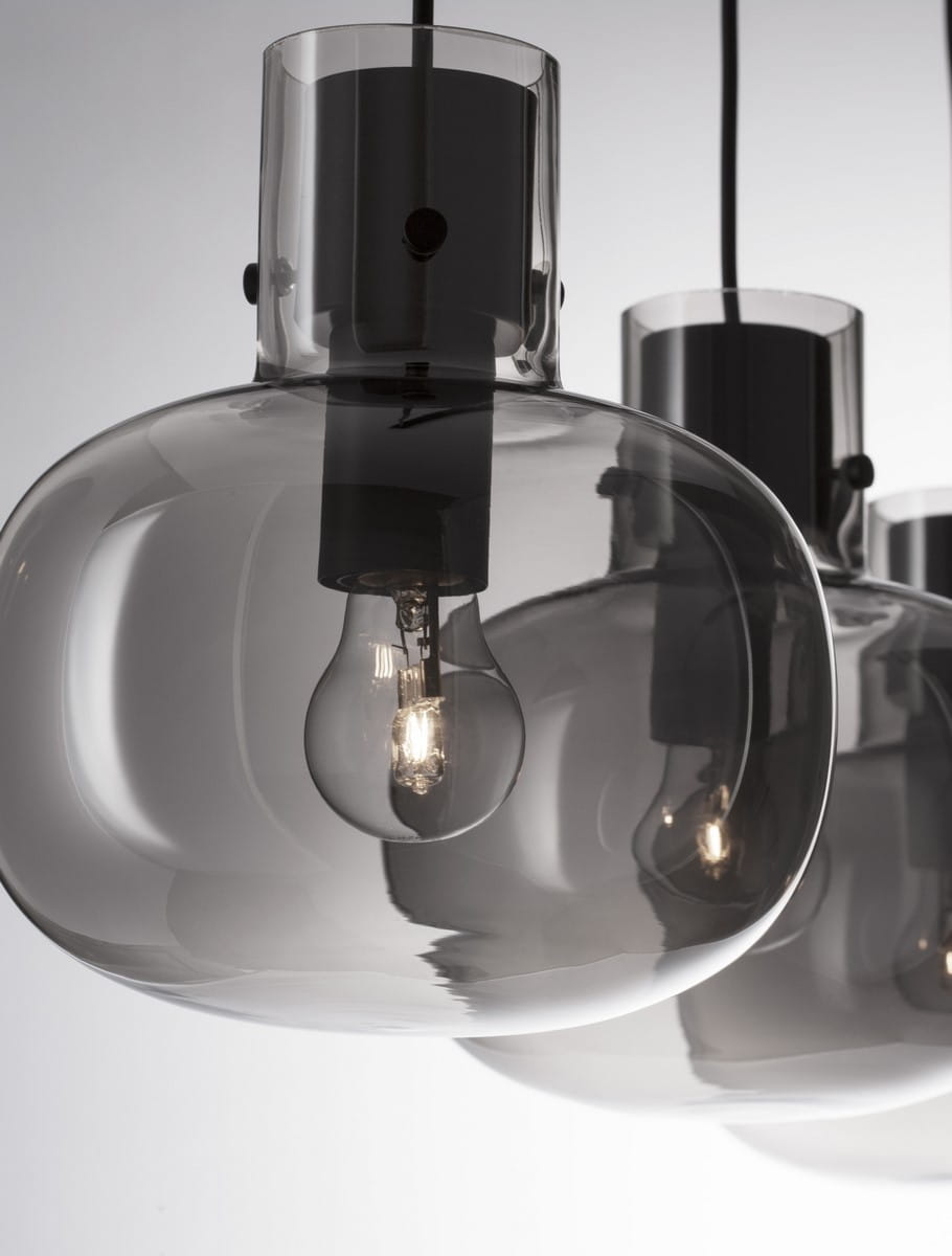 Lampa wisząca Padre w kolorze czarnym z trzema kloszami w kształcie kul, wykonanymi z przezroczystego szkła, z widocznymi żarówkami E27. Ujęcie z bliska, pokazujące detal kloszy i elementy montażowe.