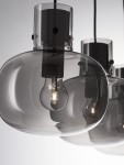 Lampa wisząca Padre w kolorze czarnym z trzema kloszami w kształcie kul, wykonanymi z przezroczystego szkła, z widocznymi żarówkami E27. Ujęcie z bliska, pokazujące detal kloszy i elementy montażowe.