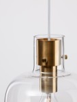 Lampa wisząca Padre z miejscem na żarówkę E27, z przezroczystym kloszem i złotym metalowym detalem. Ujęcie z bliska, pokazujące górną część lampy oraz mocowanie do sufitu. Proste tło.