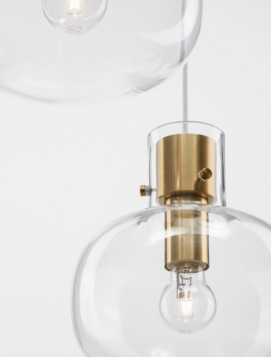 Lampa wisząca Padre z trzema źródłami światła E27, z metalowym złotym kloszem i przezroczystym szkłem. Ujęcie z bliska pokazuje detal mocowania oraz żarówki w dolnej części klosza. Proste tło podkreśla elegancki design lampy.