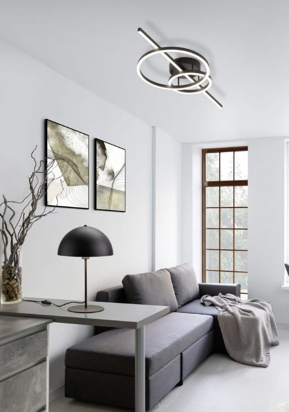 Montilla lampa sufitowa w kolorze czarnym, z pilotem, z trzema źródłami LED o łącznej mocy 54W. Lampa ma nowoczesny, geometryczny kształt z okrągłym elementem i poziomą belką, zamontowana na białym suficie w minimalistycznym wnętrzu.