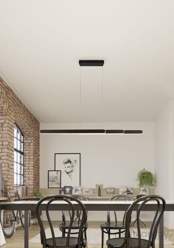 Lampa wisząca Helios 1xLED/48W w kolorze czarnym, zawieszona na cienkich linkach. Prosta, minimalistyczna konstrukcja w kształcie prostokątnego pasa. Otoczenie stanowi nowoczesna jadalnia z drewnianym stołem i stylowymi krzesłami.