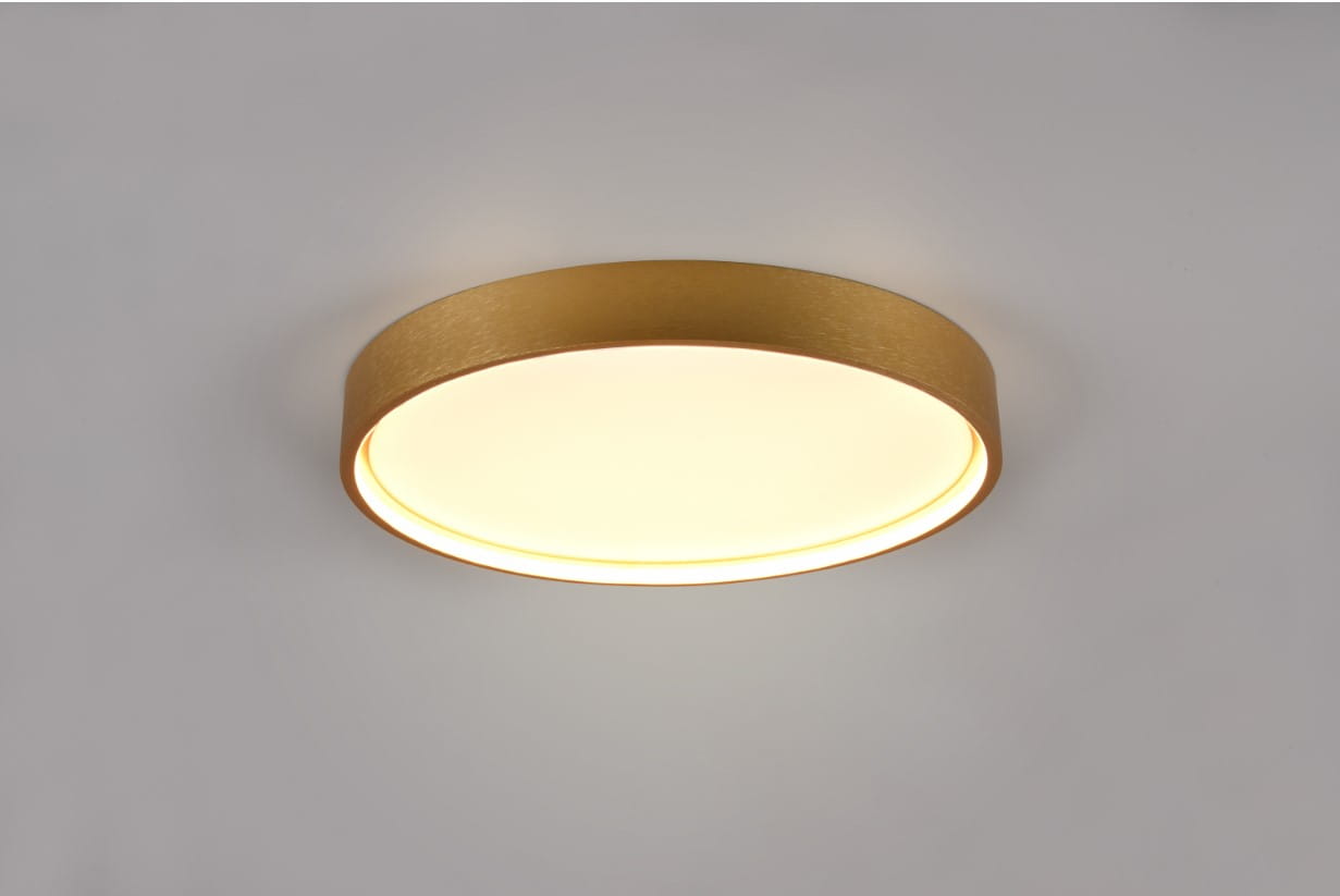 Plafon Doha 1xLED/29W w kolorze mosiądzu, okrągły, zamontowany na gładkiej, jasnej powierzchni. Światło rozchodzi się równomiernie, tworząc delikatny blask wokół. Krawędź plafonu ma matową fakturę, co podkreśla jego elegancki wygląd.