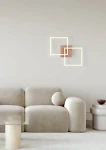 Brązowa lampa sufitowa Trail z dwoma źródłami LED o mocy 20W, zamontowana na ścianie, w otoczeniu nowoczesnego wnętrza. Wyróżnia się minimalistycznym designem i geometrycznymi kształtami. Tło w jasnych odcieniach.