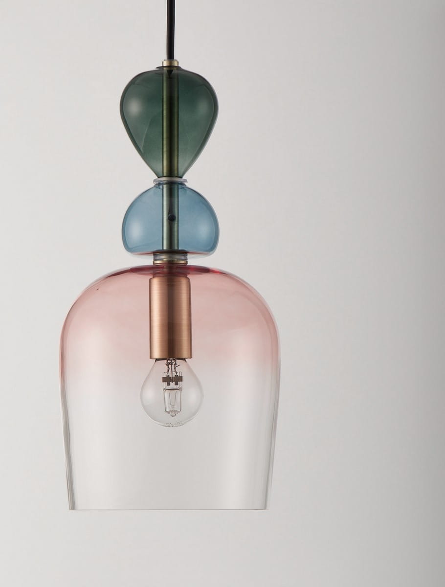 Lampa wisząca Balam z kloszem w kolorach różowym, niebieskim i zielonym, z metalowym mocowaniem w odcieniu miedzi. Produkt zawiera żarówkę E14, zawieszony na czarnym kablu. Ujęcie frontalne, na jednolitym tle.