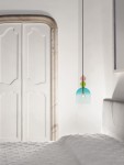 Lampa wisząca Balam 1xE14 w kolorze złotym z szklanym kloszem w odcieniach błękitu i zieleni. Posiada elegancką, minimalistyczną formę. Zawieszona na cienkim, czarnym przewodzie, w otoczeniu jasnych ścian i sypialnianego łóżka.
