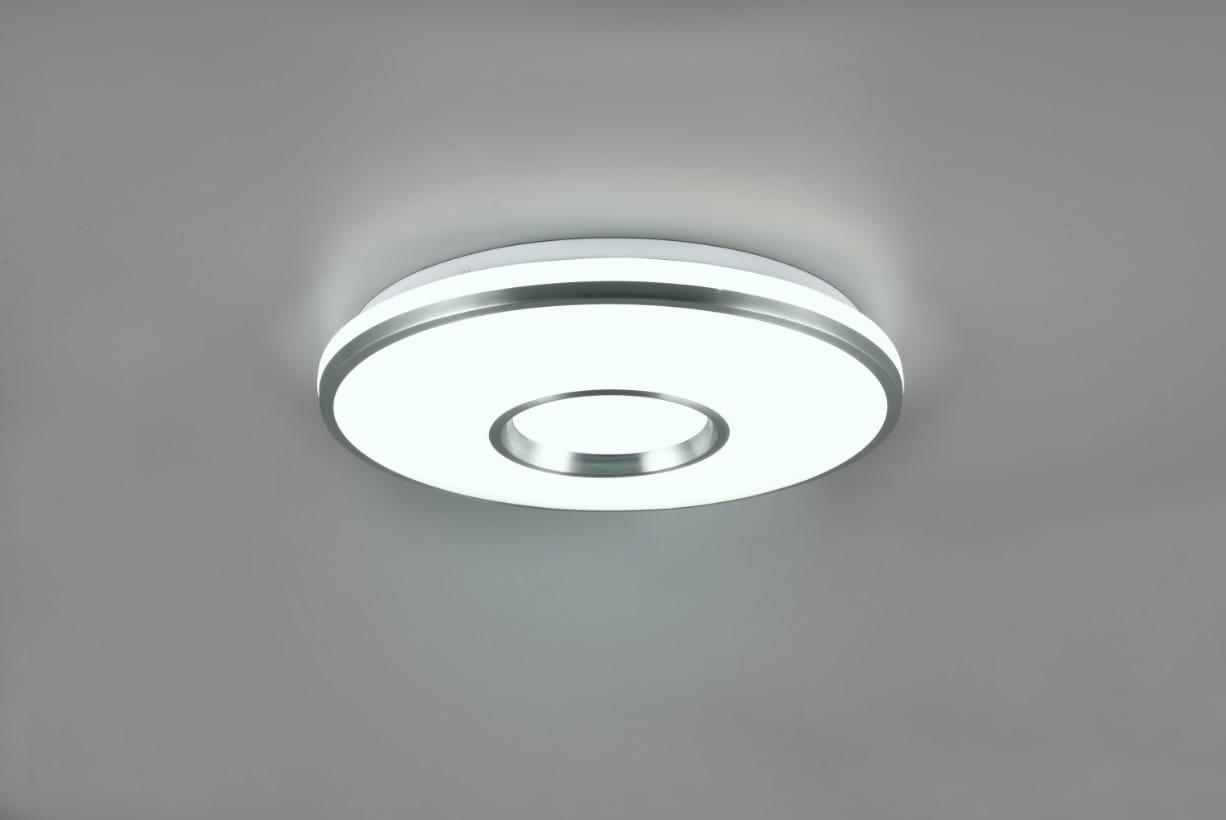 Plafon Realta w kolorze aluminium, okrągły, z centralnym otworem, z pilotem, z diodą LED o mocy 24W. Montowany na suficie, emituje białe oraz kolorowe światło RGB, idealny do nowoczesnych wnętrz.