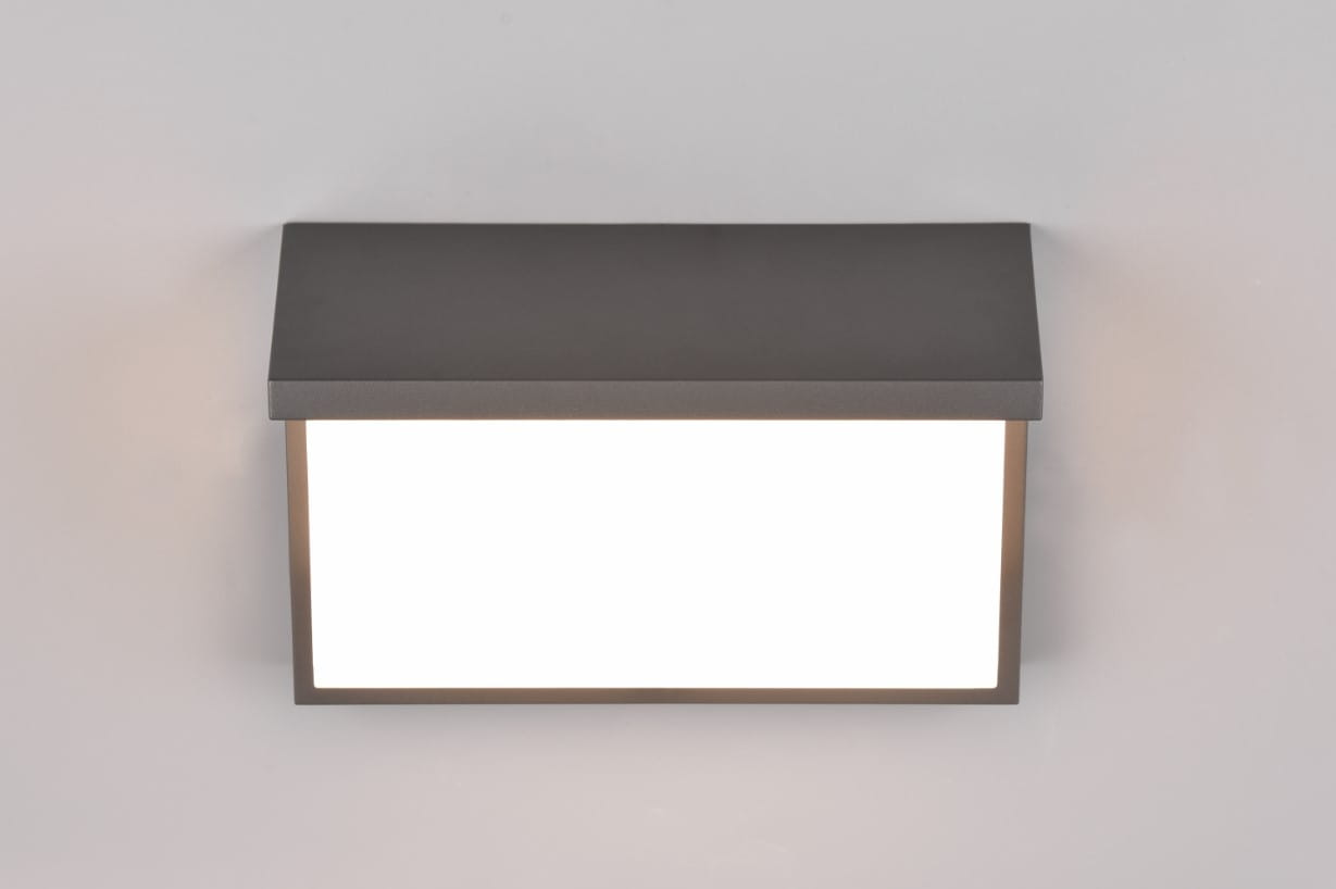 Kinkiet zewnętrzny Nestos LED w kolorze antracytowym. Produkt ma prostokątny kształt z matowym wykończeniem, oświetlenie w formie białego panelu. Ujęcie frontalne, montowany na elewacji. Idealny do oświetlenia przestrzeni zewnętrznych.
