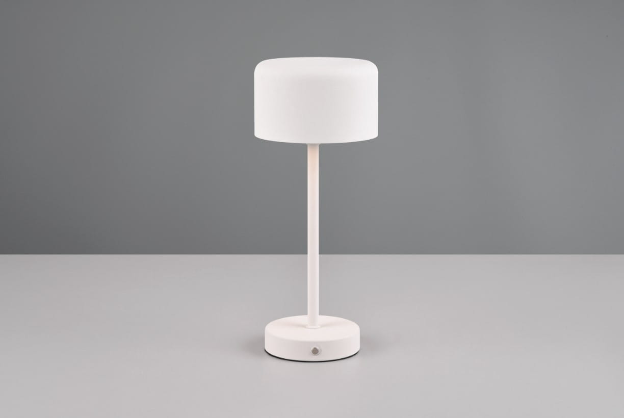 Lampa stołowa Jeff z białym kloszem, stojąca na okrągłej podstawie z widocznym przyciskiem włączania. Prosty, nowoczesny design, idealna do biura lub salonu. Ujęcie frontalne na jednolitym tle.