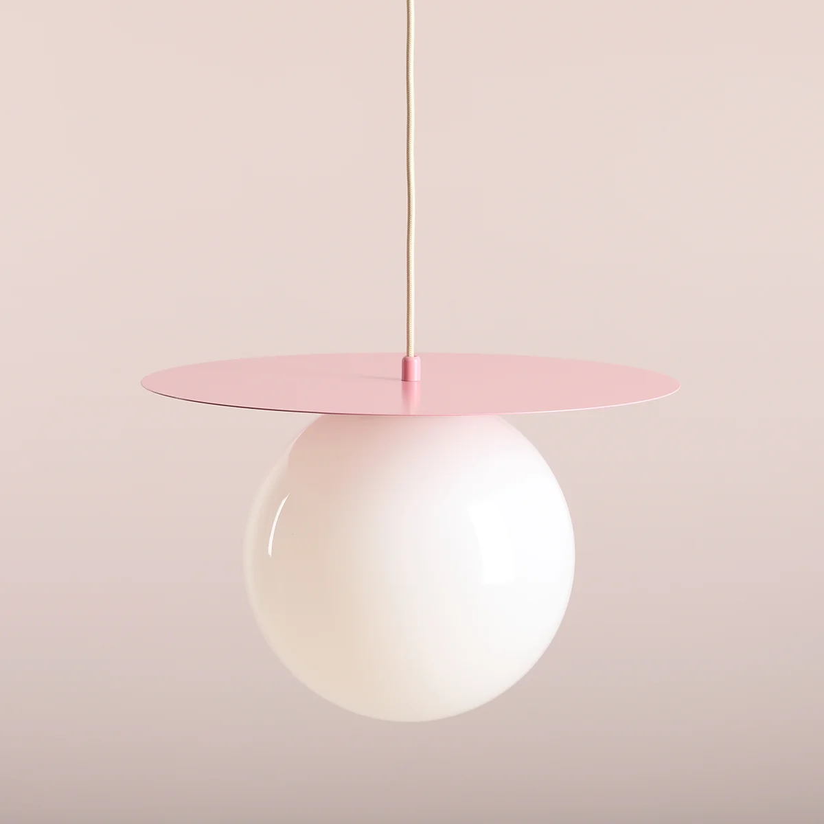 Lampa wisząca Loop Baby Pink L z kloszem w kształcie białej kuli i różowym metalowym daszkiem. Zawieszona na cienkim przewodzie, idealna do nowoczesnych wnętrz. Wymiary i detale widoczne z przodu.