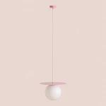 Lampa wisząca Loop Baby Pink L z oprawą w kolorze różowym i białą, szklaną kulą. Produkt zawieszony na cienkim przewodzie, z okrągłym, różowym daszkiem na górze. Prosta forma, idealna do nowoczesnych wnętrz.