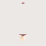 Czerwona lampa wisząca Loop Red Wine M z jedną oprawą E27. Kula ze szkła w kolorze jasnym zawieszona na cienkim przewodzie, z metalowym, okrągłym elementem w górnej części. Prosty, minimalistyczny design.