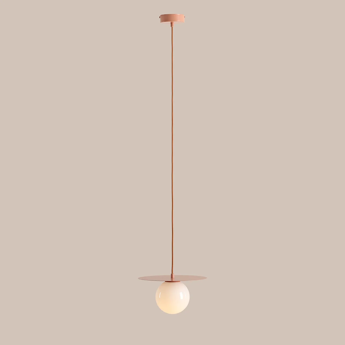 Lampa wisząca Loop Coral S z jednym gniazdem E14. Posiada okrągły, mleczny klosz zawieszony na długim, koralowym przewodzie, z płaską, okrągłą podstawą. Produkt wisi pionowo, na jednolitym tle.