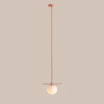 Lampa wisząca Loop Coral S z jednym gniazdem E14. Posiada okrągły, mleczny klosz zawieszony na długim, koralowym przewodzie, z płaską, okrągłą podstawą. Produkt wisi pionowo, na jednolitym tle.