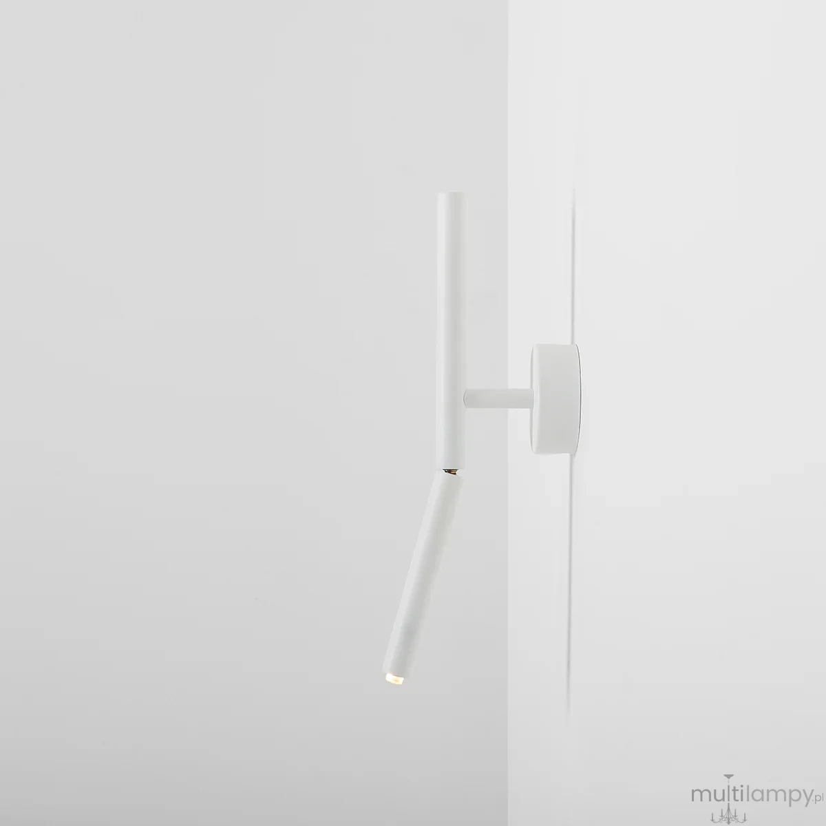 Biały kinkiet Stick 1xG9 z prostą, cylindryczną formą, zamontowany na ścianie. Posiada ruchomy ramieniem z małą, okrągłą głowicą emitującą światło. Minimalistyczny design, idealny do nowoczesnych wnętrz.