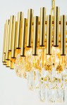 Lampa wisząca Bari 4xE27 w kolorze złotym, z metalowymi rurkami i kryształowymi elementami. Ujęcie z góry, ukazujące szczegóły konstrukcji i efekty świetlne. Wymiary i dodatkowe detale nie są widoczne.