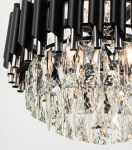 Lampa wisząca Wersal 6xE27 w kolorze chromu i czerni. Posiada sześć metalowych kloszy oraz kryształowe elementy w kształcie diamentów, które odbijają światło, tworząc efektowną iluminację. Ujęcie z bliska, ukazujące detale i teksturę.