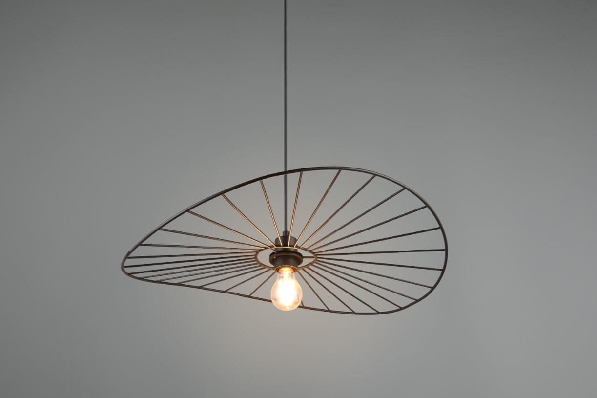 Lampa wisząca Chapeau w kolorze czarnym, z metalową konstrukcją w kształcie lekko asymetrycznego talerza. Wyposażona w gniazdo E27 z widoczną żarówką. Wisi na cienkim przewodzie w neutralnym otoczeniu.