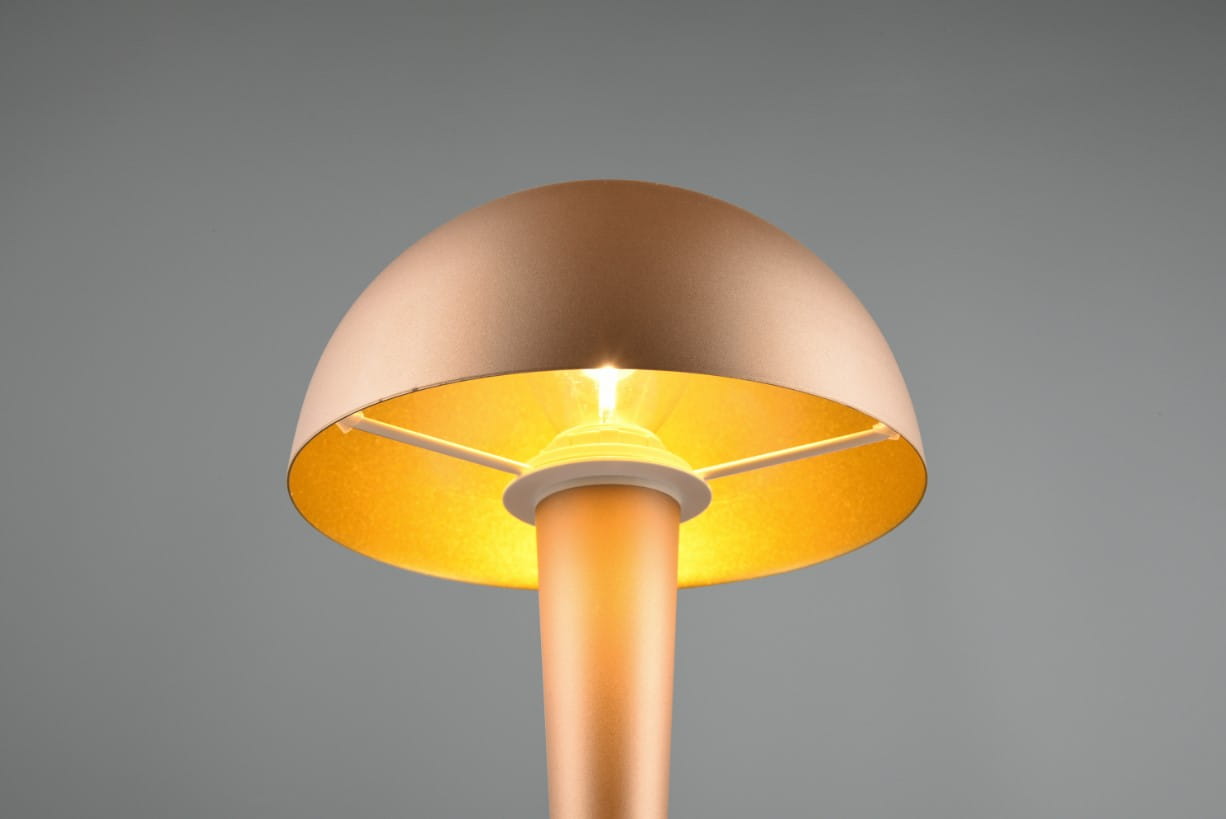 Lampa stołowa Canaria z brązowym kloszem w kształcie półkuli, z białym trzonkiem. Widoczna żarówka E14 w centralnej części, emitująca ciepłe światło. Ujęcie z góry, na szarym tle, podkreślające elegancki design.