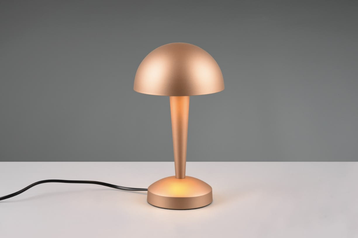 Brązowa lampa stołowa Canaria z kloszem w kształcie półkuli i stożkowym trzonem. Ustawiona na okrągłej podstawie, z widocznym przewodem zasilającym. Lampa o ciepłym świetle, idealna do biura lub sypialni.