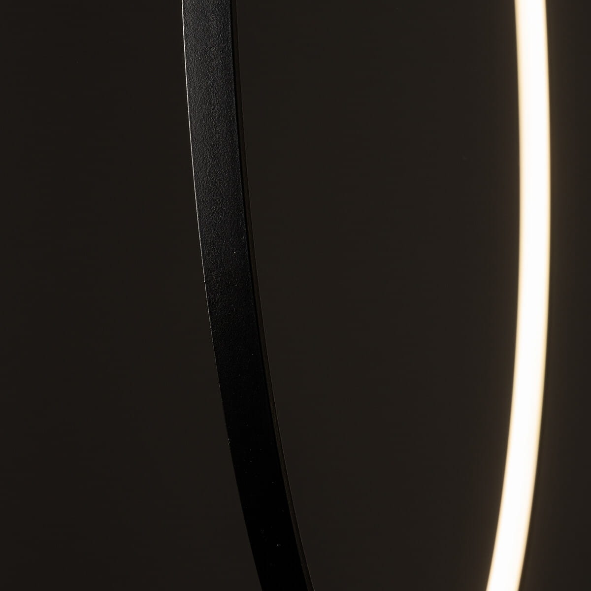 Czarna lampa wisząca Circolo D60 z technologią LED, o mocy 21W i barwie światła 3000K. Widoczny detal okrągłego kształtu z matowym wykończeniem i subtelnym źródłem światła w formie pierścienia. Ujęcie z bliska, podkreślające strukturę materiału.