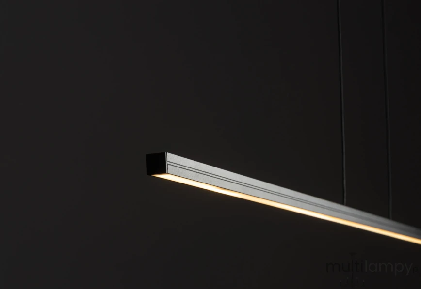 Lampa wisząca Bar L120, czarna, o prostokątnym kształcie, z wbudowanym źródłem LED 21W, 3000K. Ujęcie z boku, pokazujące delikatne światło emitowane z dolnej krawędzi, zawieszona na cienkich żyłkach, na ciemnym tle.