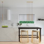 Lampa wisząca Pastelo 5xG9 w kolorze złotym, zawieszona na cienkich linkach w nowoczesnej kuchni. Kąt ujęcia frontalny, prezentuje lampa nad czarnym stolikiem z metalowymi stołkami. Tło jasne, z marmurowym blatem i oknem z widokiem na rośliny.