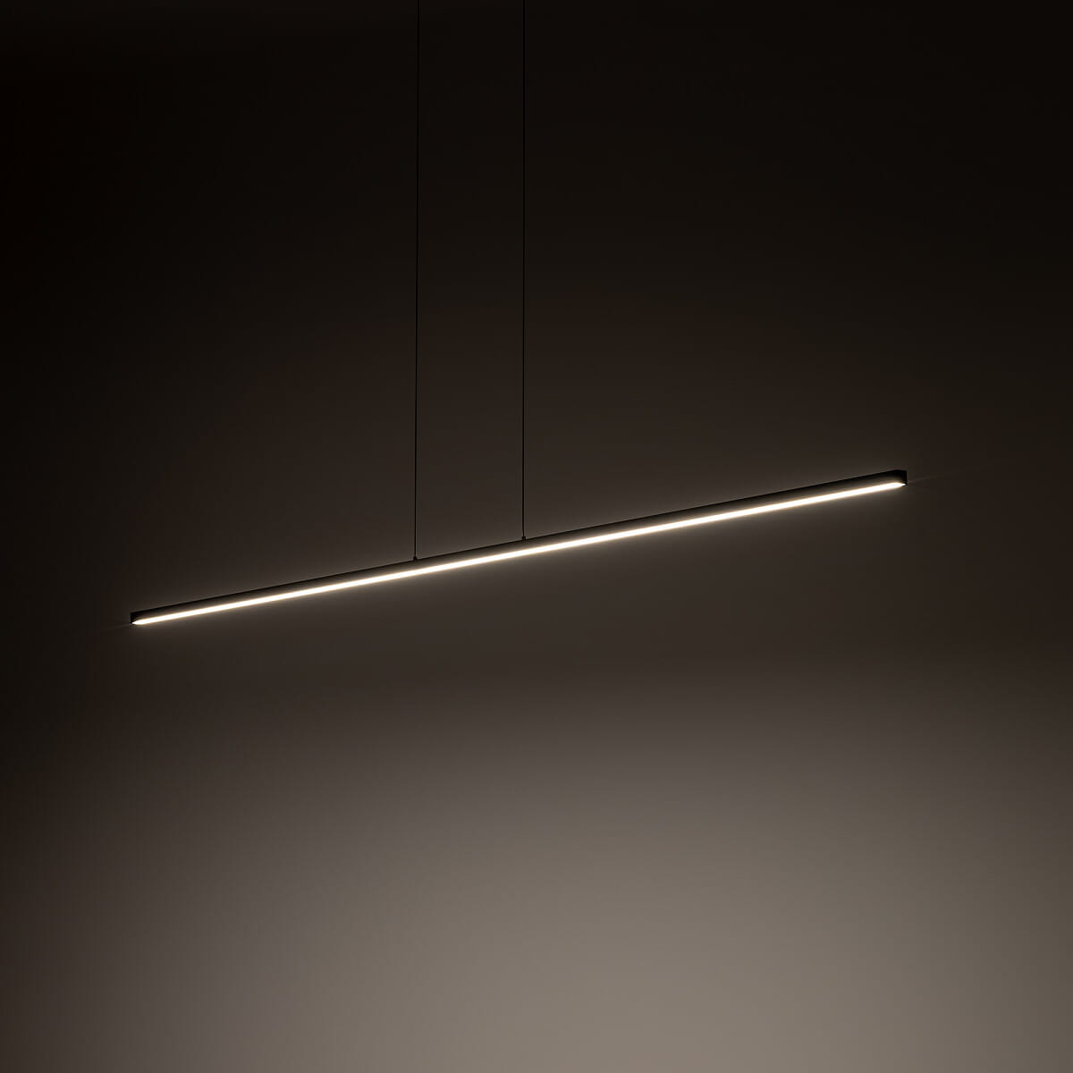 Lampa wisząca Bar L180 w kolorze czarnym, o prostokątnym kształcie, z jedną diodą LED 27W, emitującą światło o temperaturze 3000K. Zawieszona równolegle do ściany, na ciemnym tle, z delikatnym podświetleniem.