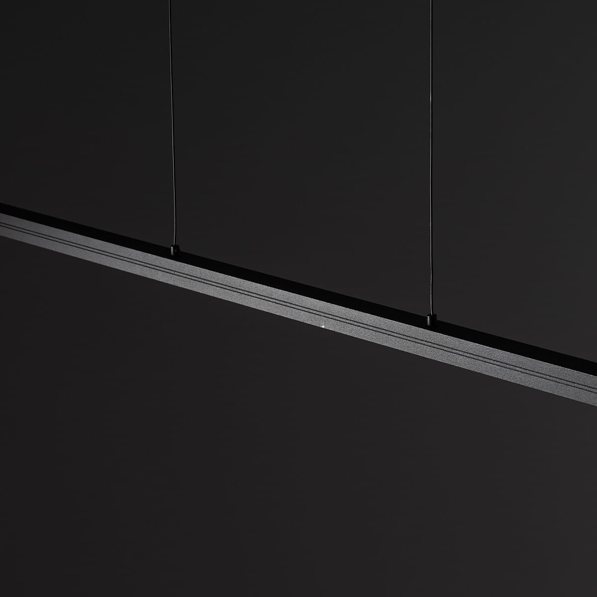 Lampa wisząca Bar L180 w kolorze czarnym, wykonana z metalu, z jedną diodą LED o mocy 27W i temperaturze barwowej 4000K. Prezentuje minimalistyczny design, zawieszona na cienkich linkach, w kształcie prostokąta.