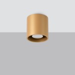Lampa sufitowa Orbis w kolorze złotym, o cylindrycznym kształcie, z miejscem na żarówkę GU10, montowana na suficie. Widok z dołu na gładką, matową powierzchnię. Tło w odcieniu szarym.