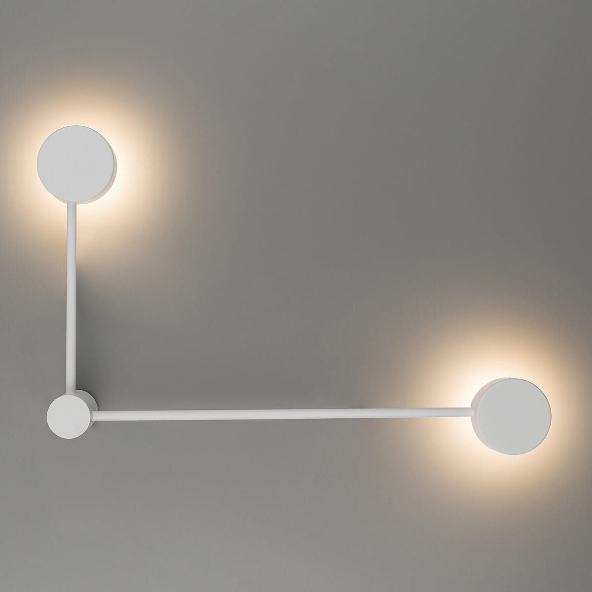 Kinkiet Orbit P 2xGX53 w kolorze białym, z dwiema okrągłymi oprawami świetlnymi, zamontowany na szarym tle. Produkt prezentuje minimalistyczny design z prostą, liniową konstrukcją oraz okrągłymi elementami.