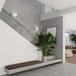 Kinkiet Toni 1xG9 w kolorze białym, zamontowany na ścianie w nowoczesnym wnętrzu. Oświetlenie przy schodach, z minimalistycznym designem, obok zielona roślina w doniczce i szara ściana.