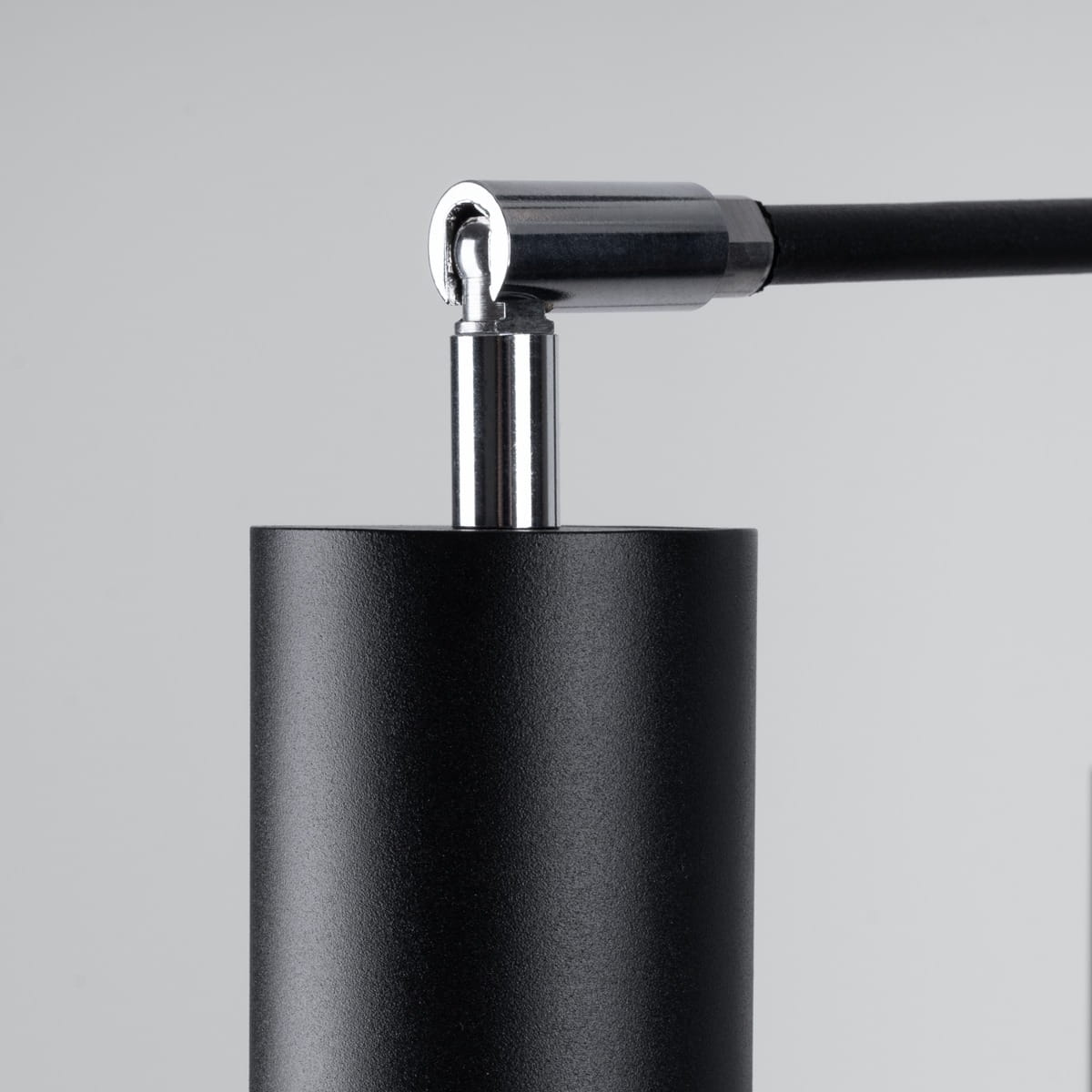 Lemmi lampa wisząca w kolorze czarnym z metalowym elementem. Widoczne mocowanie i przewód. Produkt w zbliżeniu, ukazujący detale konstrukcji oraz wykończenia.