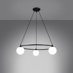 Lampa wisząca Yoli z trzema źródłami światła G9, czarna. Produkt wisi na trzech cienkich linkach, z okrągłą podstawą. Kuliste, białe klosze równomiernie rozmieszczone na okręgu, tworzą nowoczesny wygląd. Tło w odcieniu szarości.