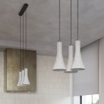 Lampa wisząca Rea z trzema kloszami w kształcie dzwonu, wykonana z betonu w odcieniu jasnoszarym. Zawieszona na cienkich, czarnych linkach, montowana do sufitu. Oświetlenie idealne do nowoczesnych wnętrz, wykończone metalowymi detalami.