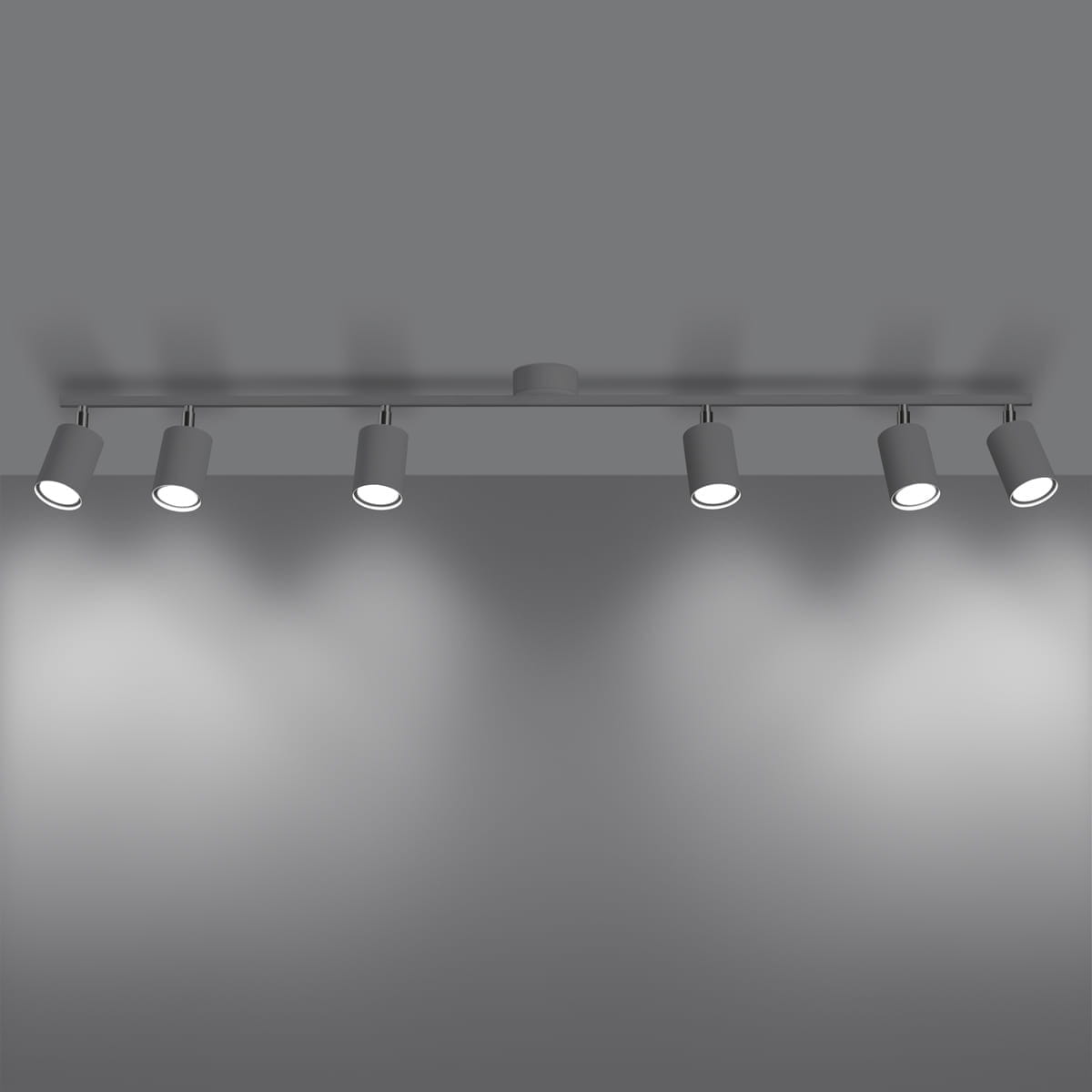 Lemmi lampa sufitowa (spot) w kolorze białym z sześcioma ruchomymi oprawami na żarówki GU10. Ujęcie frontalne, zamontowana na suficie, emitująca jasne światło na gładką, szaro-białą powierzchnię.