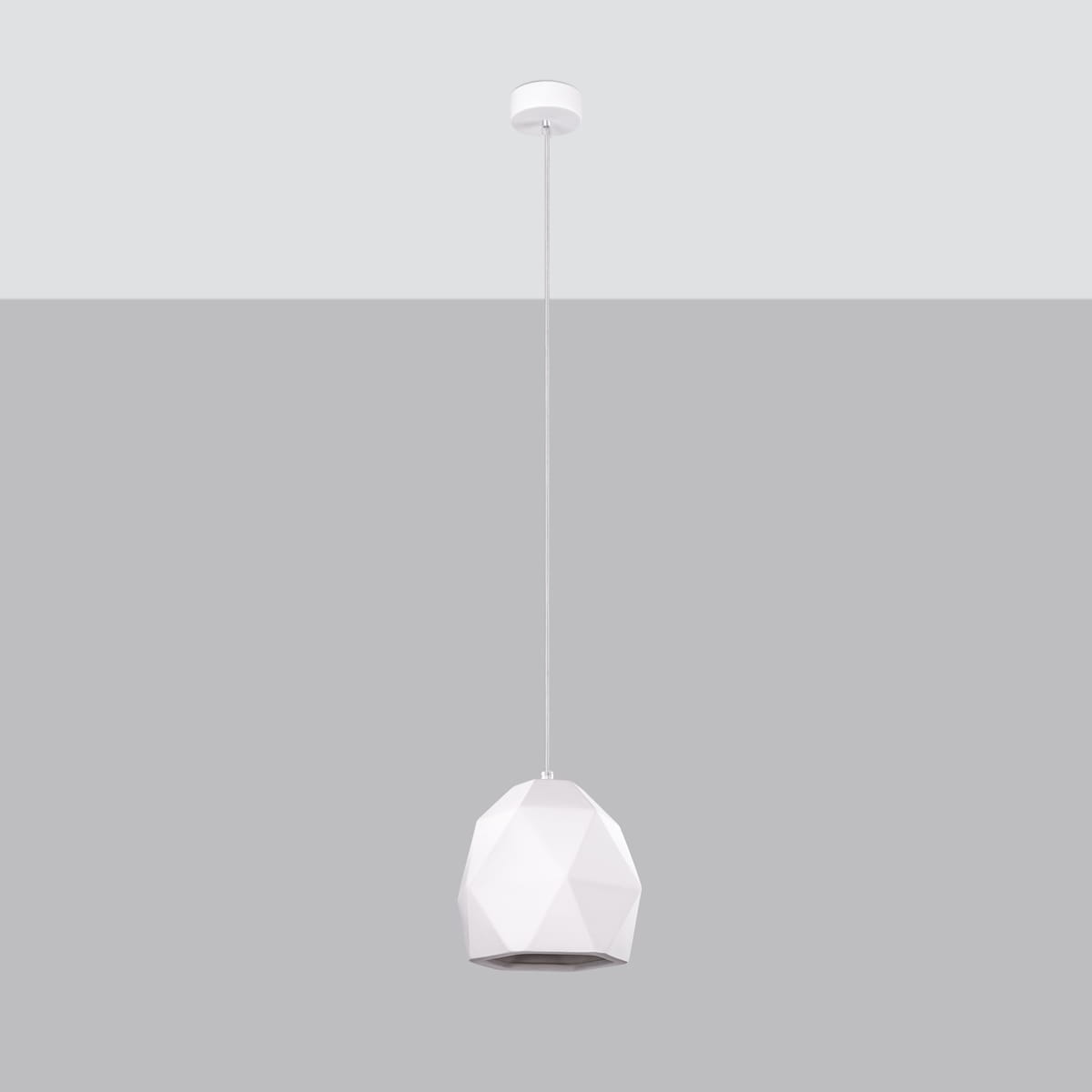 Biała lampa wisząca Mint z kloszem w kształcie wielościanu, zawieszona na cienkim przewodzie. Klosz ma gładką, matową powierzchnię i jest zamontowany na okrągłej podstawie sufitowej. Tło w odcieniach szarości.