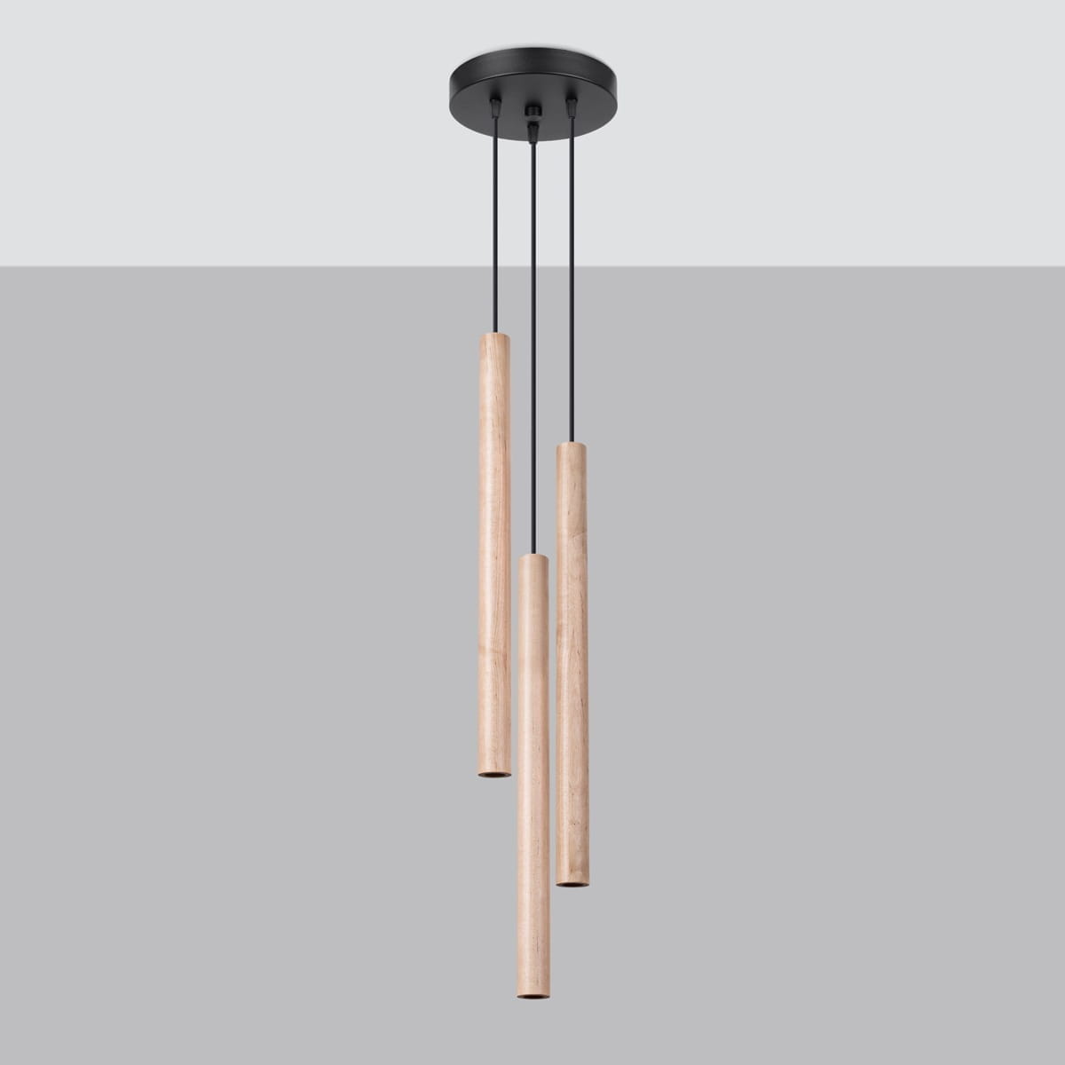 Lampa wisząca Pastelo 3xG9 w kolorze czarnym i drewnianym, z trzema cylindrycznymi, drewnianymi elementami zawieszonymi na czarnych linkach. Ujęcie z góry, na tle jednolitego szarego koloru.