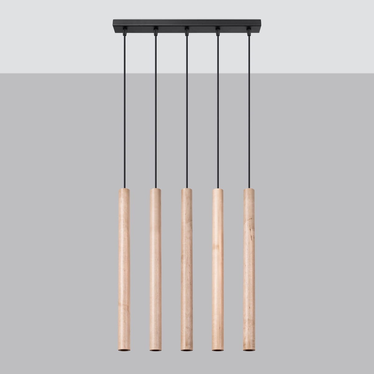 Lampa wisząca Pastelo w kolorze czarnym z pięcioma drewnianymi, cylindrycznymi kloszami. Produkt zawieszony na czarnych linkach, montowany do sufitu. Tło w odcieniach szarości, co podkreśla minimalistyczny design.