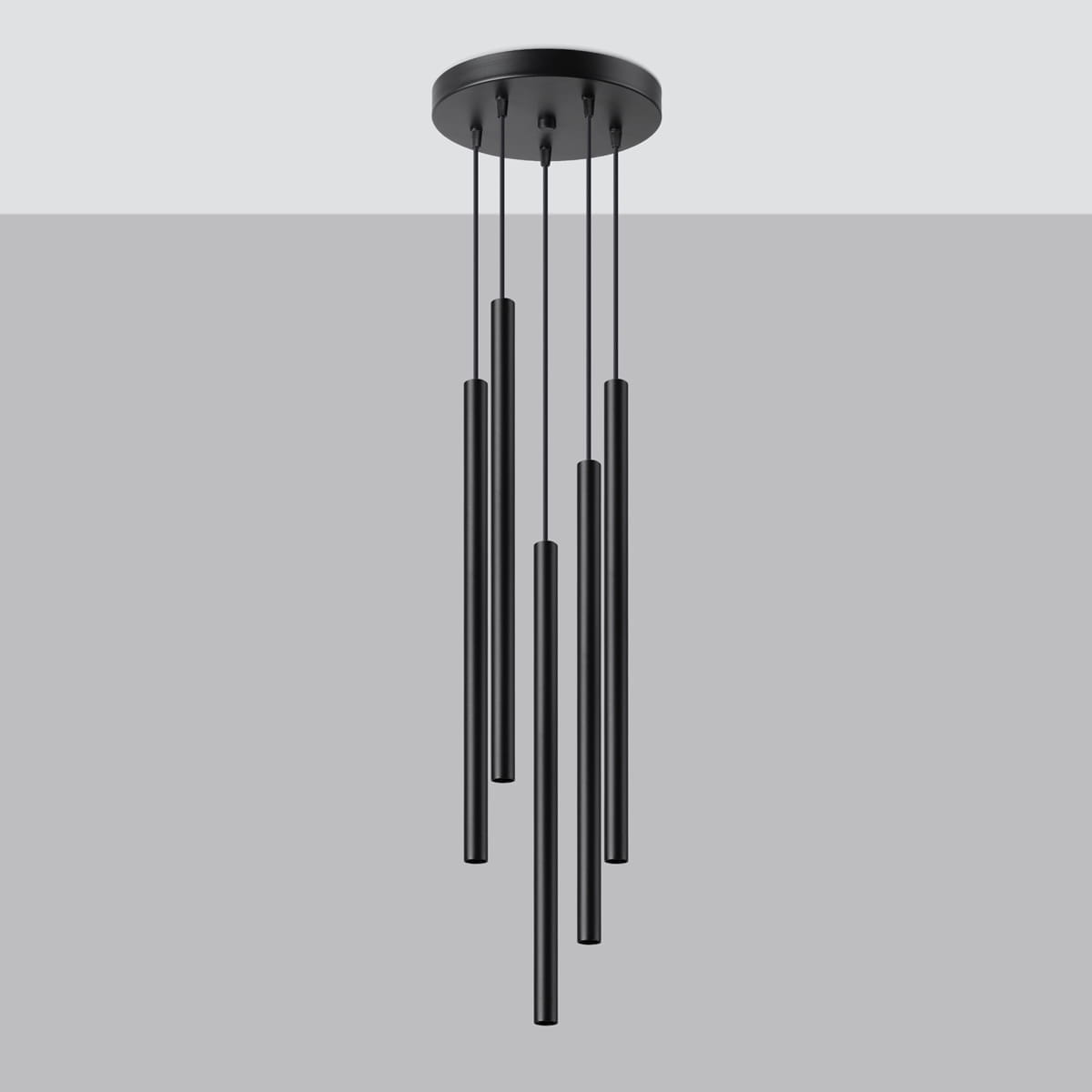 Lampa wisząca Pastelo w kolorze czarnym, składająca się z pięciu długich, cylindrycznych elementów zawieszonych na cienkich linkach. Zainstalowana na okrągłej podstawie sufitowej. Idealna do nowoczesnych wnętrz.