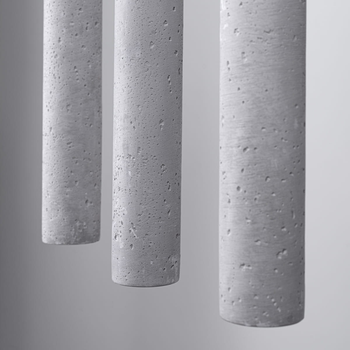 Lampa wisząca Pastelo 3xG9, w kolorze czarnym z betonowymi kloszami. Widoczne trzy cylindryczne klosze z fakturą betonu, zawieszone w prostym układzie. Tło jednolite, co podkreśla minimalistyczny styl lampy.
