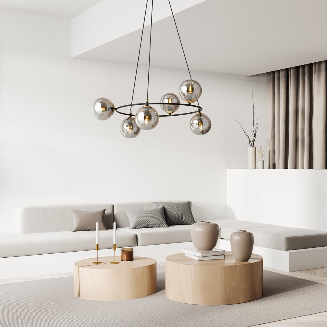 Lampa wisząca Azura w kolorze czarnym i grafitowym, z sześcioma kulistymi kloszami, zawieszona na cienkich kablach. W tle nowoczesny salon z jasnymi meblami, okrągłymi stolikami i dekoracjami.