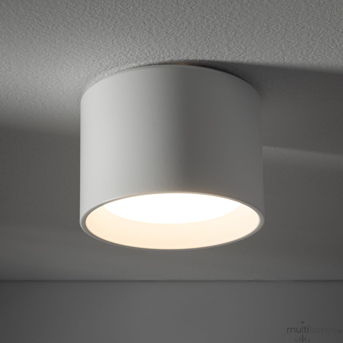 Lampa sufitowa Maun w kolorze białym, o okrągłym kształcie, zamontowana na suficie. Wewnątrz znajduje się źródło światła GX53. Produkt ma matową powierzchnię i jest przeznaczony do użytku w pomieszczeniach o podwyższonej wilgotności (IP54).