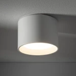 Lampa sufitowa Maun w kolorze białym, o okrągłym kształcie, zamontowana na suficie. Wewnątrz znajduje się źródło światła GX53. Produkt ma matową powierzchnię i jest przeznaczony do użytku w pomieszczeniach o podwyższonej wilgotności (IP54).