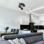 Lampa sufitowa Elza w kolorze czarnym, z trzema oprawami na żarówki E27, zamontowana na suficie. Widoczna w nowoczesnej kuchni z białymi meblami i drewnianym stołem, w otoczeniu eleganckiego wystroju.