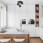 Lampa sufitowa Elza w kolorze czarnym z trzema oprawami na żarówki E27, zamontowana na suficie w nowoczesnej kuchni, z białymi szafkami i drewnianym blatem.