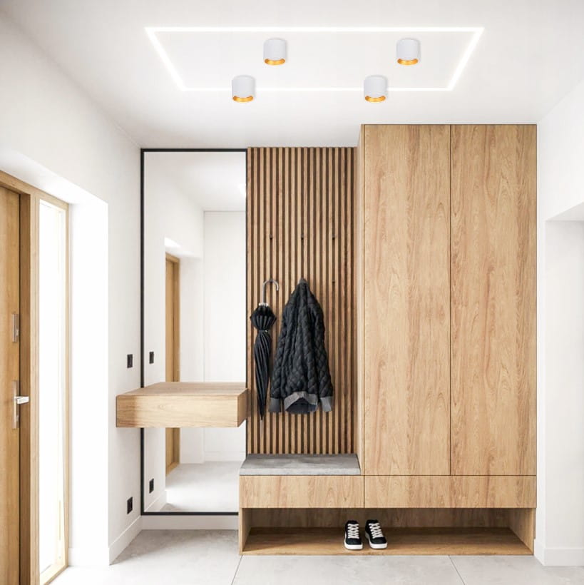 Lampa sufitowa Golda w kolorze białym i złotym, montowana na suficie, z cylindrycznymi kloszami. Zestaw czterech lamp w nowoczesnym wnętrzu z drewnianymi elementami, widoczna w aranżacji przedpokoju.