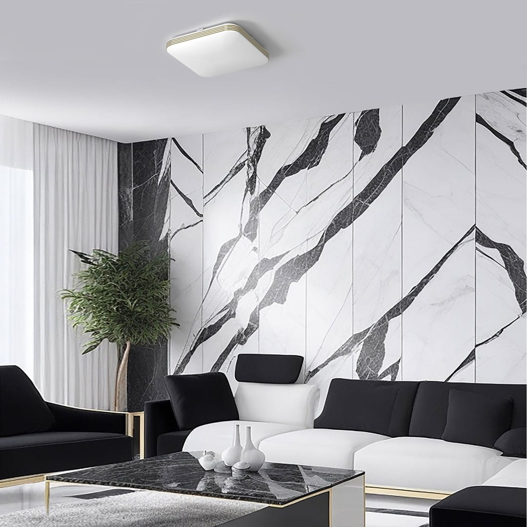 Plafon LED Dabar D33x33 w kolorze białym z złotymi detalami, o mocy 17W i temperaturze barwowej 4000K, montowany sufitowo. Zdjęcie pokazuje go w nowoczesnym wnętrzu z marmurową ścianą i eleganckim meblami.