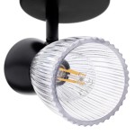 Lampa sufitowa typu spot w kolorze czarnym z jedną oprawą na żarówkę E14. Szklany klosz o fakturze w pionowe prążki, zamontowany na okrągłej podstawie. Ujęcie z boku, ukazujące szczegóły klosza oraz miejsce na żarówkę.