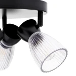 Czarna lampa sufitowa typu spot z trzema oprawami E14. Każda oprawa ma przezroczysty, teksturowany klosz z pionowymi żłobieniami, zamontowana na okrągłej podstawie. Ujęcie z boku, ukazujące detale kloszy i mocowania.